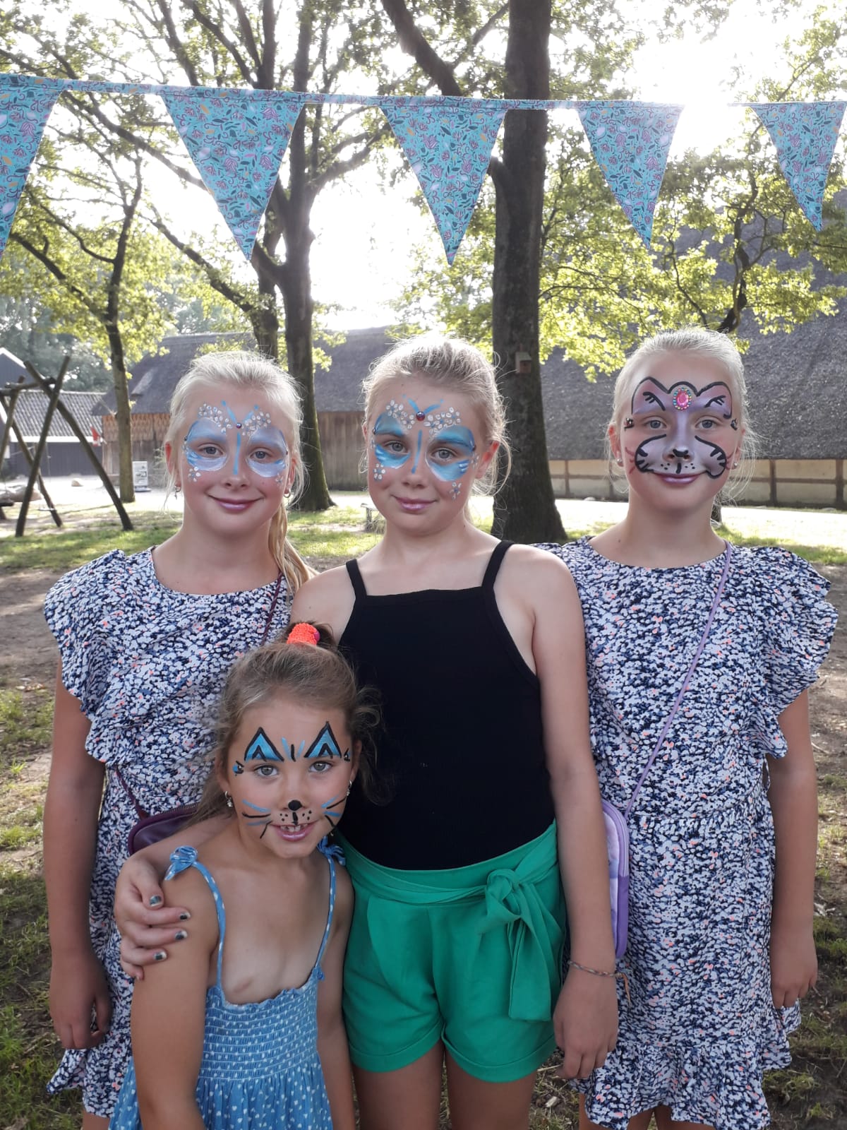 Vier geschminkte meisjes poseren voor onze foto tijdens Oermarkt Orvelte. Smink vlinder, leeuw, kat.