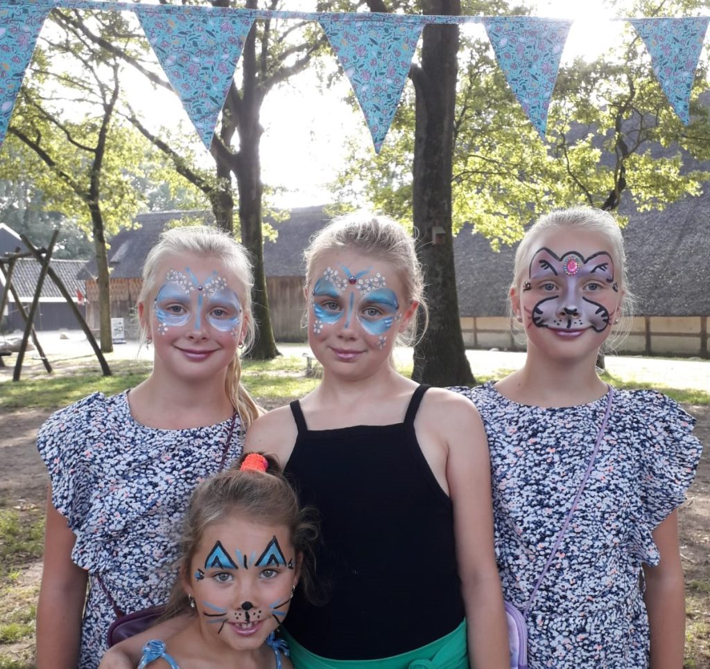Vier Geschminkte meisjes festival Drenthe dorpsfeest buiten onder de bomen met vlaggetjes